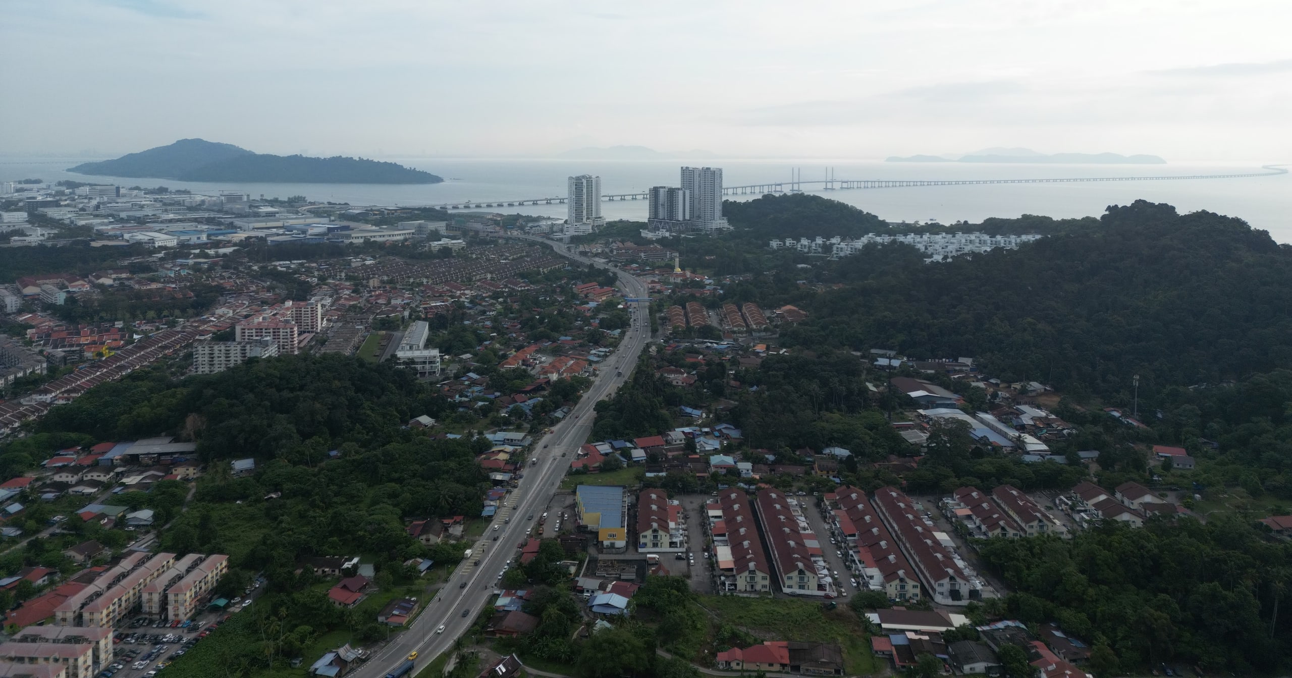 Aerial view over Batu Maung towards the coast, with the forested hill, the Second Bridge landing and Pulau Jerejak offshore
