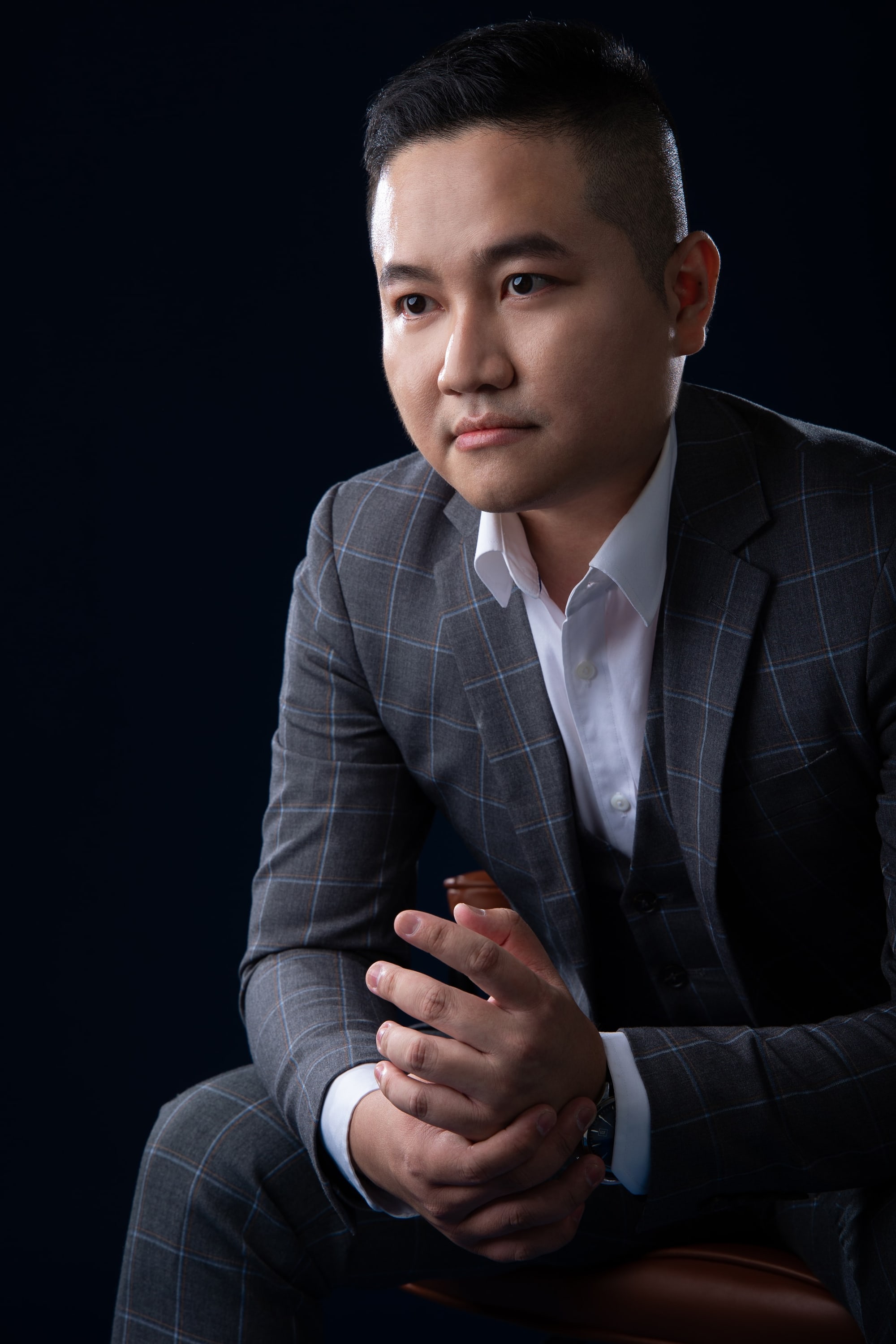 Kevin Lee, property advisor, seated, in a grey check suit